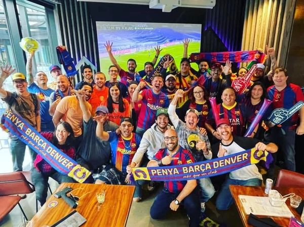 Group cheering with FC Barcelona scarves in a lively fan gathering.