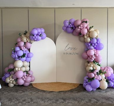 Organic balloon garland backdrop in purple, blush, and ivory with modern arch panels for a bridal sh