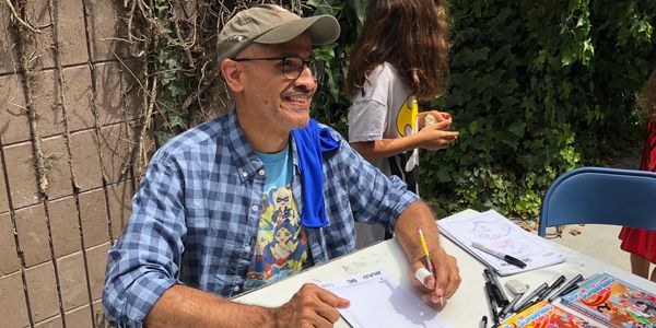 Yancey sketching at an event at a comic book store.