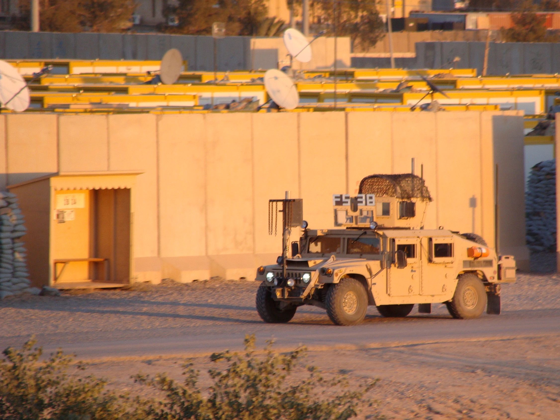 Military armored vehicle in a desert compound.