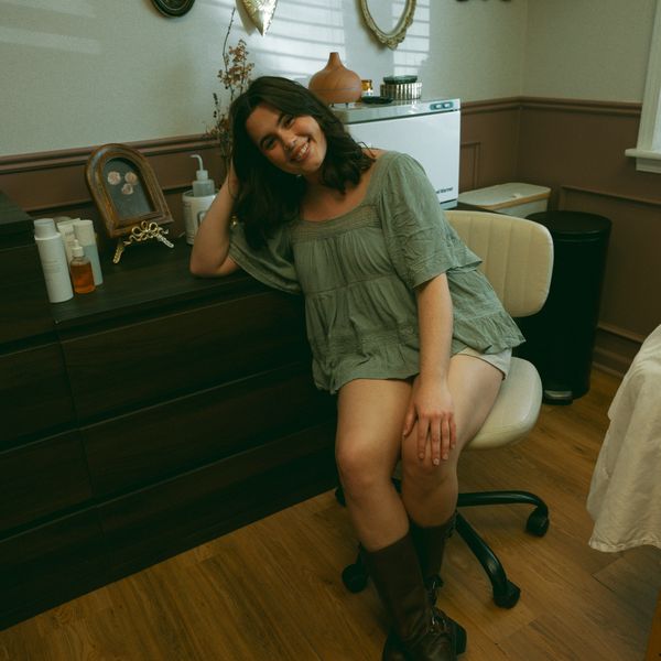 Young woman smiling while seated on an office chair in a cozy room.