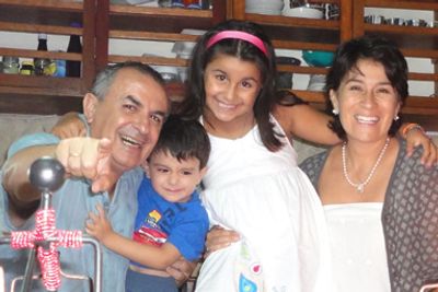 Una familia sonriente posando junta en una casa.
