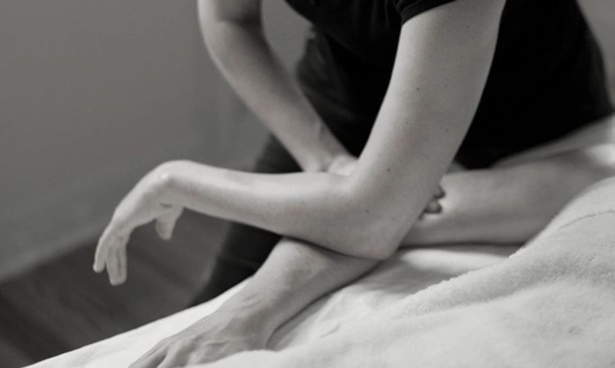 Massage therapist massaging arm