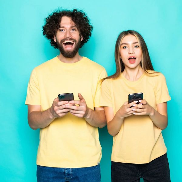 summer camp directors with smartphone smiling and happy about their camp app