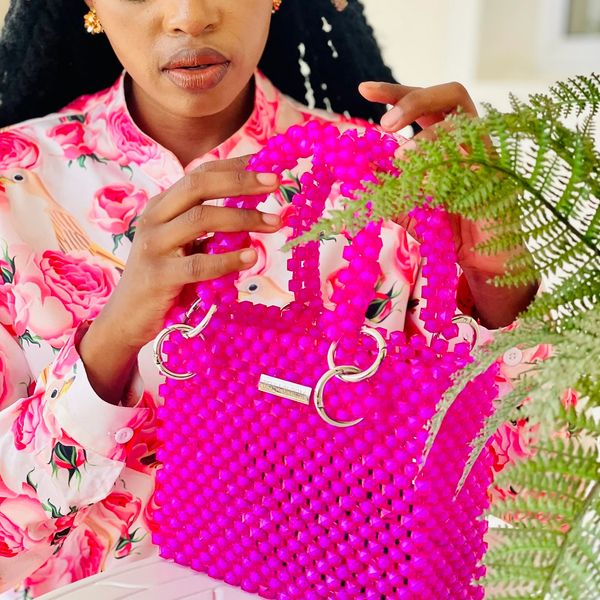 Floral shirt or plain, a bright pink beaded handbag is what you need