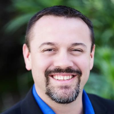 Smiling man with a goatee and dark hair.