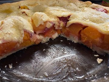 A sliced peach pie with golden crust.