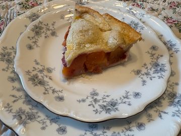 Slice of fruit pie on a floral plate.