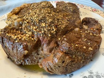 Seasoned cooked steak on a plate.