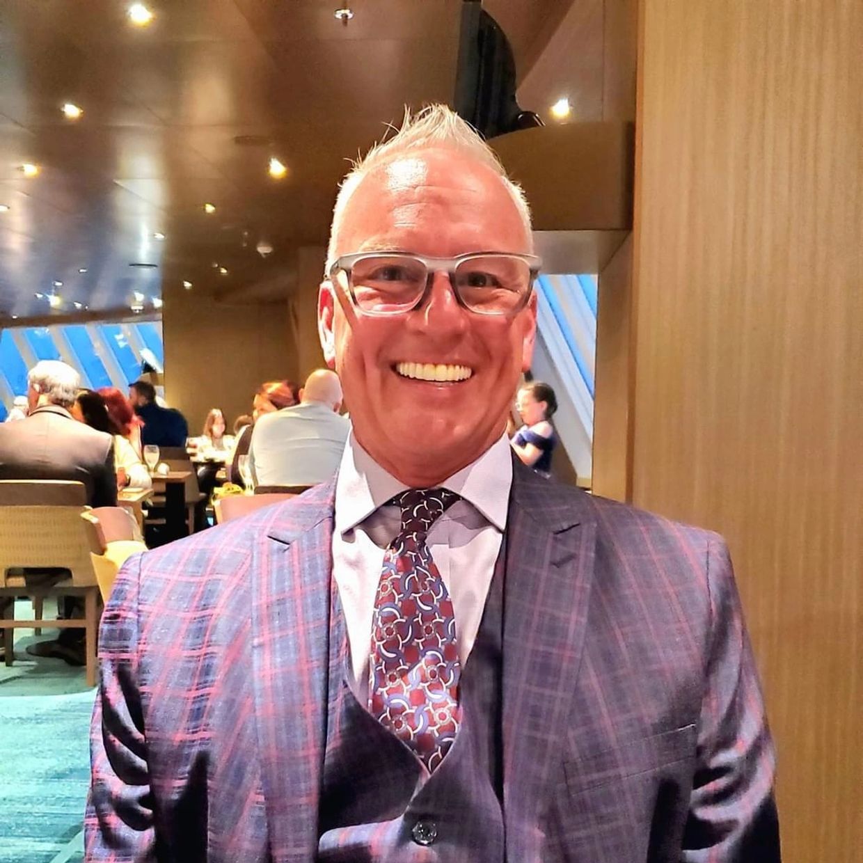 owner and founder Mark Killam sitting dressed in purple suit.