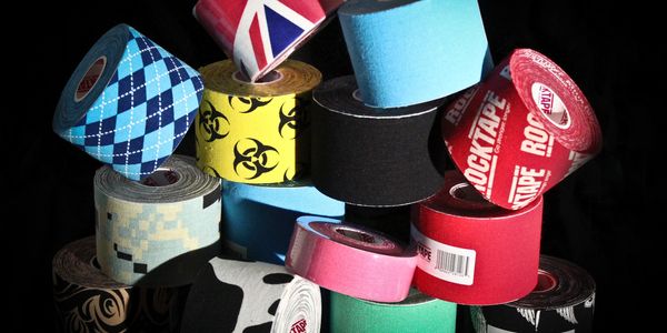 Stack of various colorful kinesiology tapes.