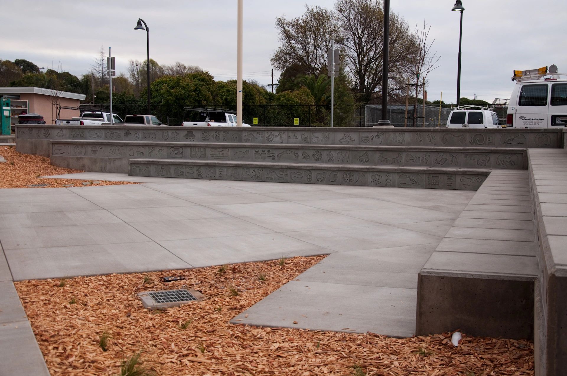 A three tiered amphitheater with decorative concrete bas relief seating viewed from one end.