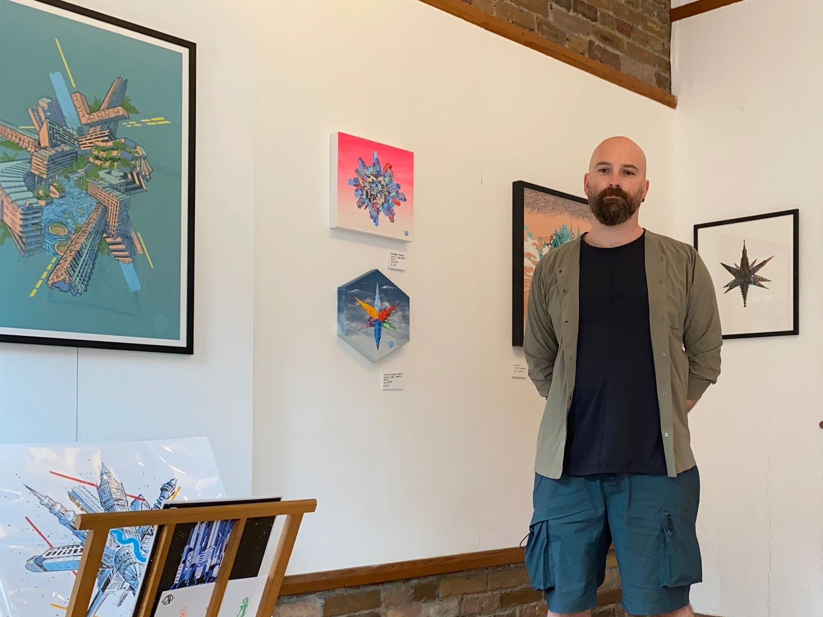 Sam Kerridge standing in an exhibition of his artworks