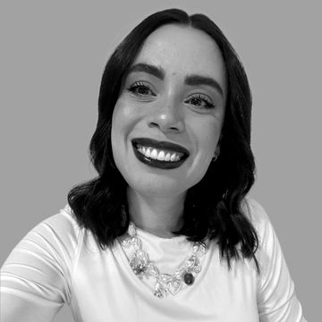 Mulher sorridente com cabelo escuro e batom escuro.