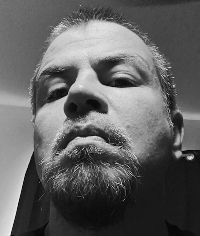 Close-up of a serious man with a short beard and mustache.