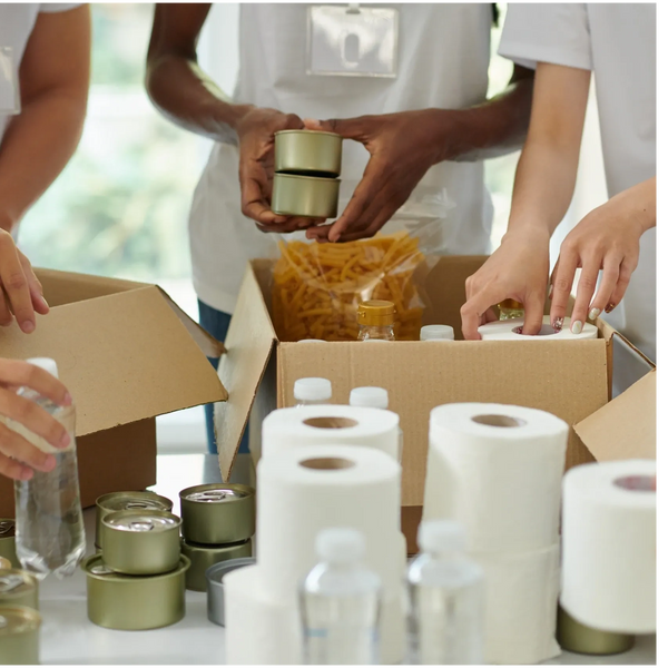 Volunteers packing essential supplies into boxes for distribution.