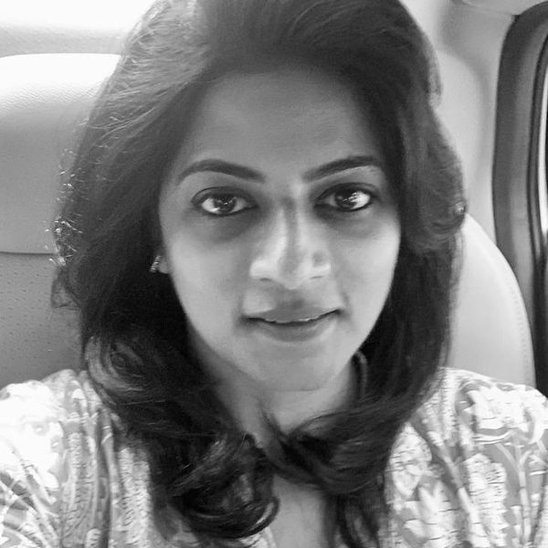 Black and white selfie of a woman with wavy hair inside a car.