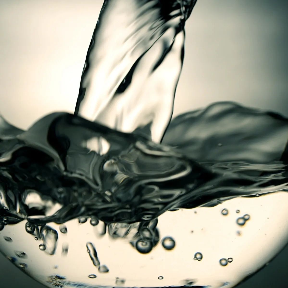 Close-up of water swirling dynamically in a transparent glass bowl