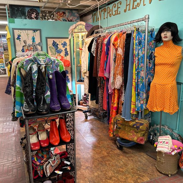 Looking inside a corner booth filled with vintage clothing.