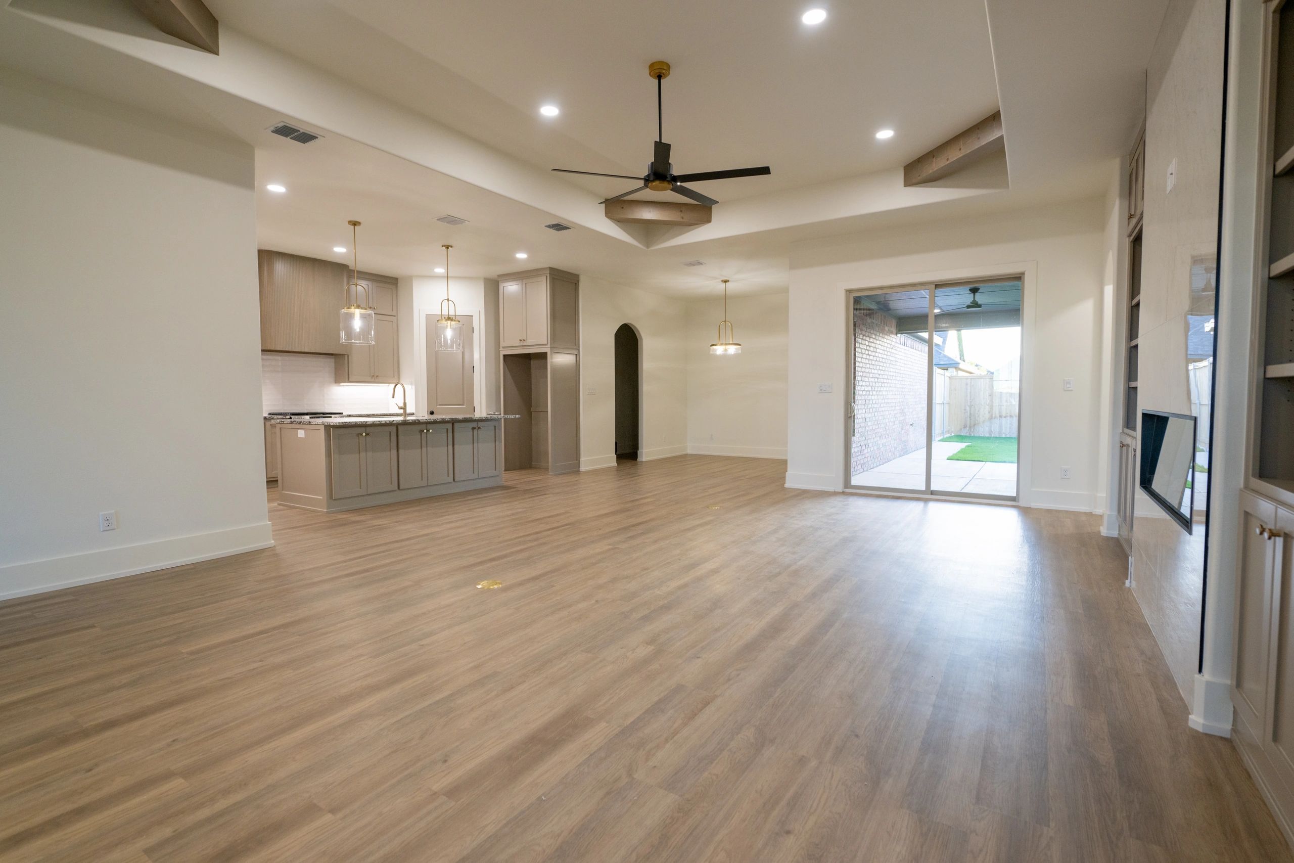 Spacious modern open kitchen and living area with wooden flooring.