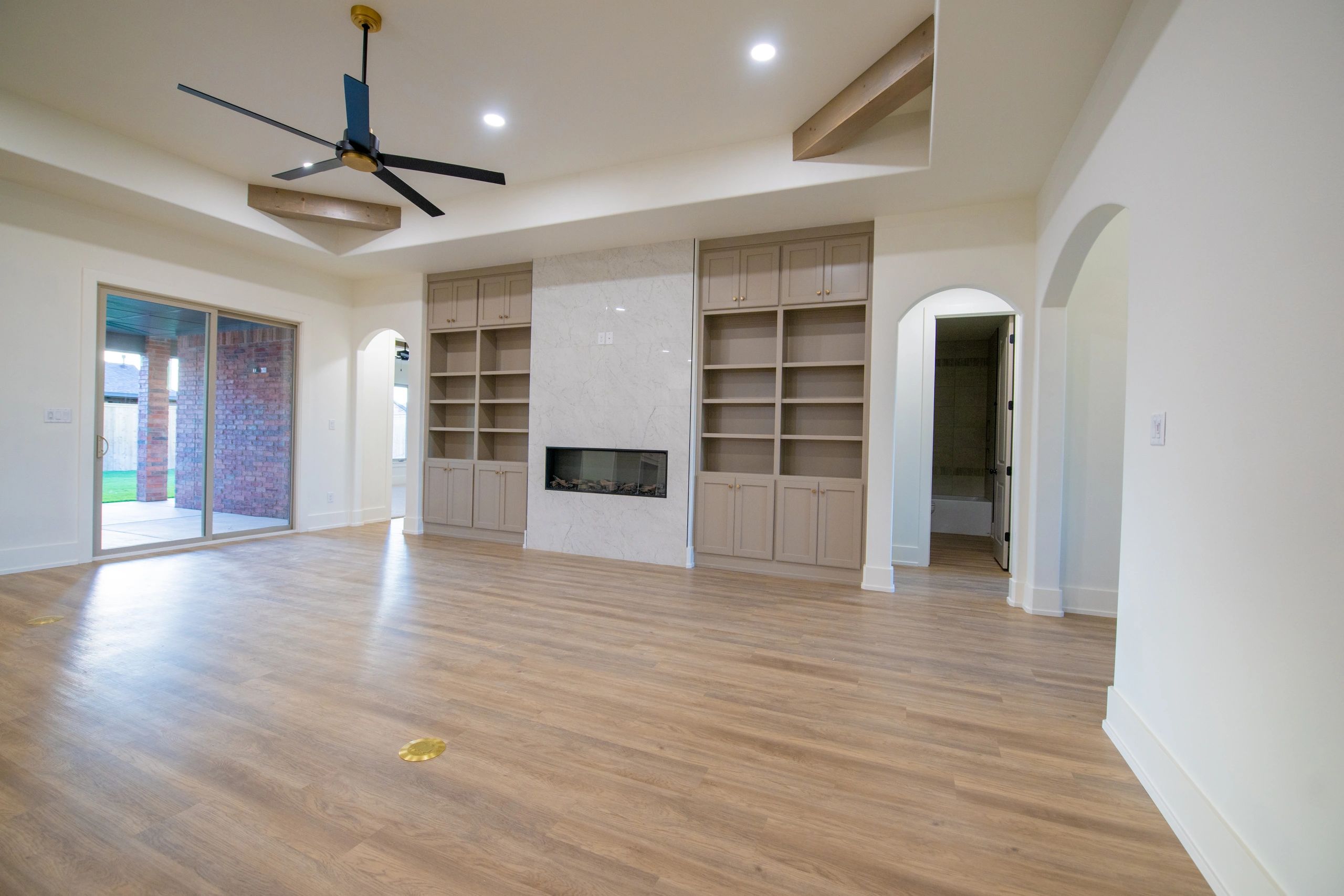 Modern living room with fireplace and ceiling fan.