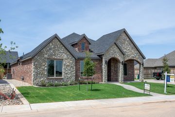 Modern stone and brick house with a front lawn.