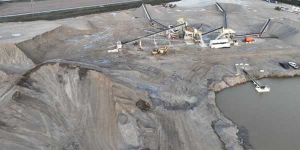A large mining site with equipment and a water body nearby.