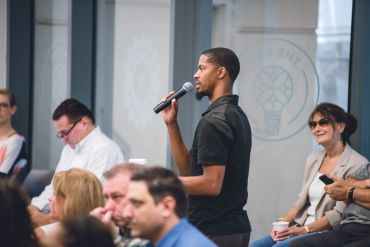 Man speaking into a microphone at an event.