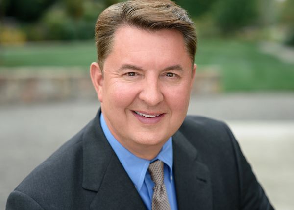 Smiling man in business suit outdoors.