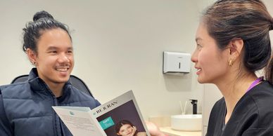 A woman discusses a magazine with a man in a casual setting.