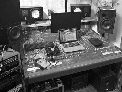 A professional music recording and mixing setup with speakers and a laptop.
