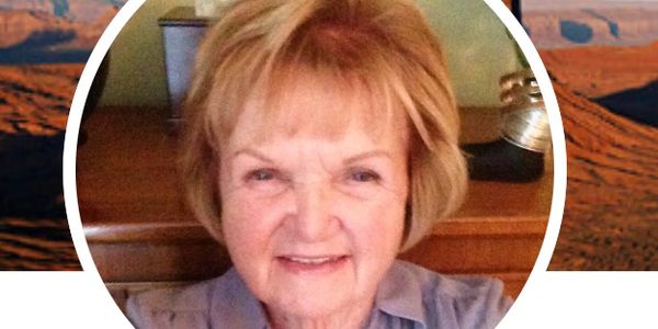 Smiling elderly woman with short blonde hair indoors.