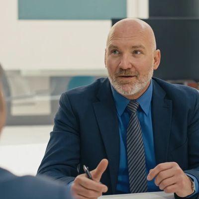 A businessman in a suit discussing at a meeting.