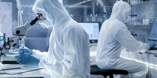 Scientists in full protective suits working in a high-tech laboratory.
