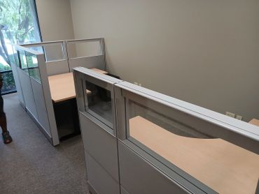 Empty office cubicles with glass dividers.