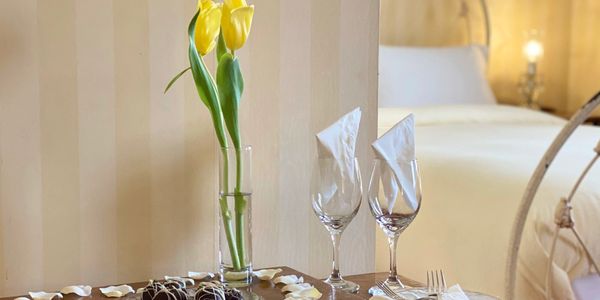 Chocolate covered strawberries flowers and wine glasses on a table