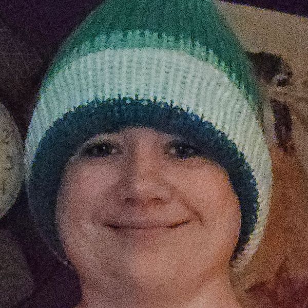 Person smiling wearing a striped knit hat.