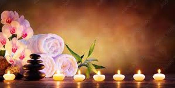 Spa setting with candles, towels, and orchids.