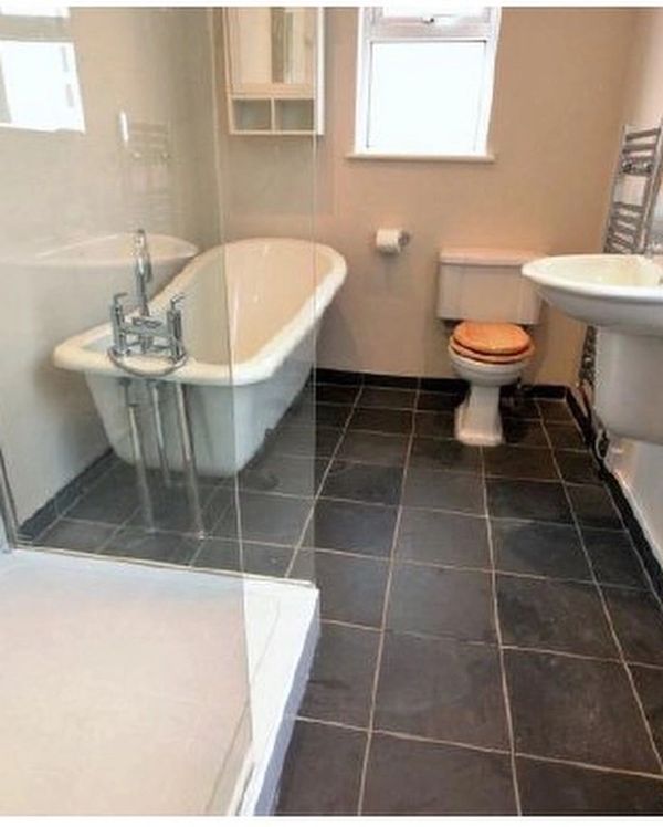 A modern bathroom with a bathtub, toilet, sink, and glass shower enclosure.
