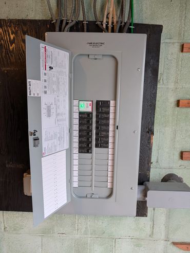 Electrical breaker panel with labeled switches and a green indicator light.