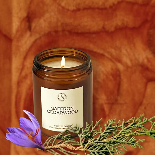 Saffron CedarWood candle displayed next to the candle on a cedar wood block with saffron flowers.