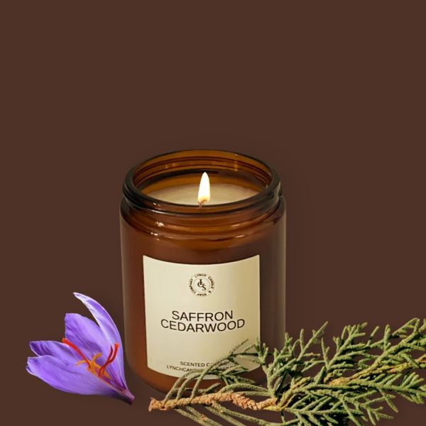 Saffron CedarWood candle displayed next to the candle on a cedar wood block with saffron flowers.