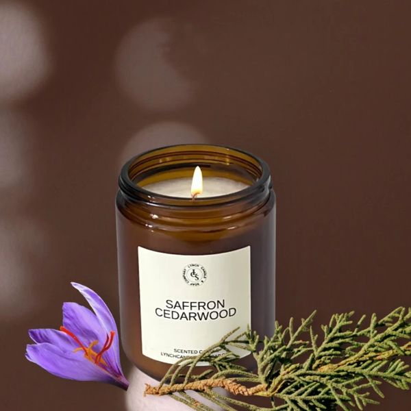 Saffron CedarWood candle displayed next to the candle on a cedar wood block with saffron flowers.