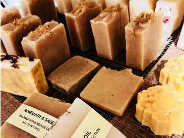 Natural handmade soaps displayed on green leaves.