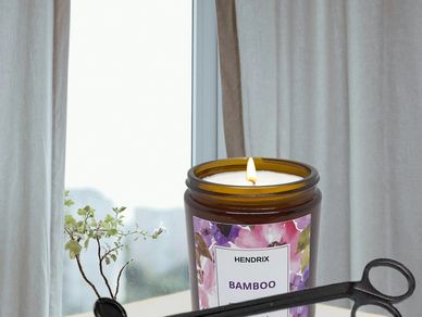 Lit jasmine-scented candle in a brown glass jar.