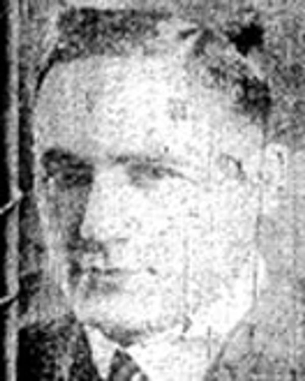 Black and white close-up portrait of a man with short hair.