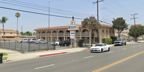 Street view of a residential building with parked cars.