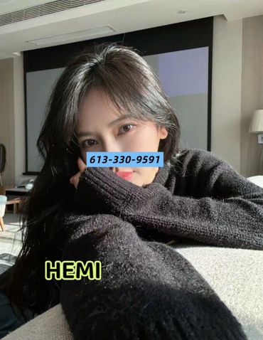 Young woman with long dark hair taking a cozy selfie indoors.
