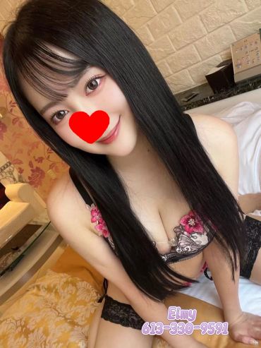 Young woman in black lingerie poses on bed.