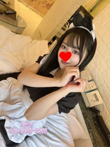 A person in a maid outfit making a heart shape with hands.